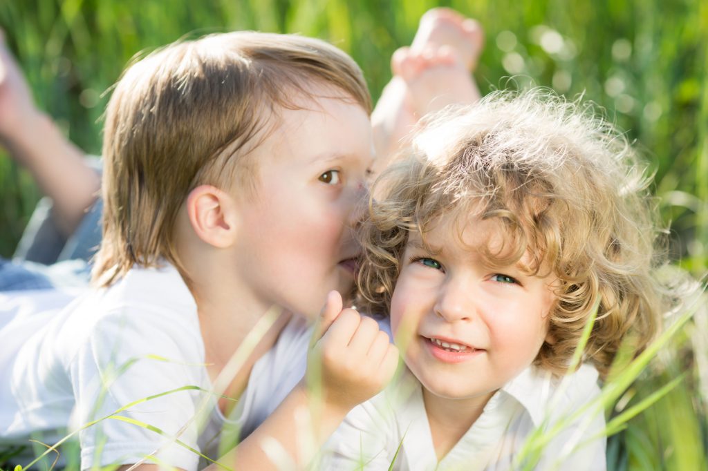 Happy children playing outdoors in spring grass
