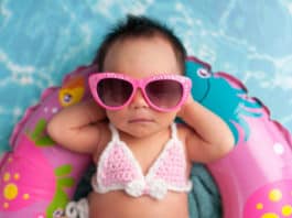 Sonnencreme und Sonnenhut am Strand, Newborn Baby Girl Wearing Sunglasses and a Bikini Top