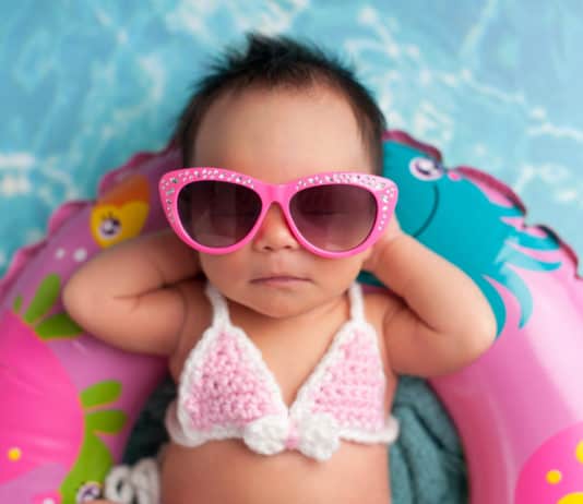 Sonnencreme und Sonnenhut am Strand, Newborn Baby Girl Wearing Sunglasses and a Bikini Top