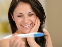 Delighted woman holding pregnancy test