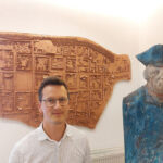 Mario Zetzsche vor einem Stadt-Relief und einer preisgekrönten Skulptur   des Gdansker Bildhauers Slawoj Ostrowski von Friedrich dem Großen